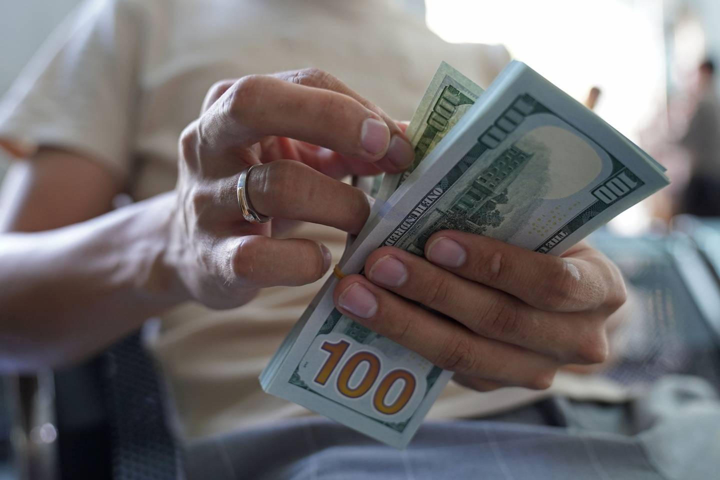 Un hombre cuenta billetes de dólares estadounidenses en una oficina de cambio el miércoles 2 de marzo de 2022.