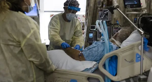 Un trabajador de salud trata a un paciente en la unidad de cuidados intensivos de Covid-19 del Freeman Hospital West en Joplin, Misuri.