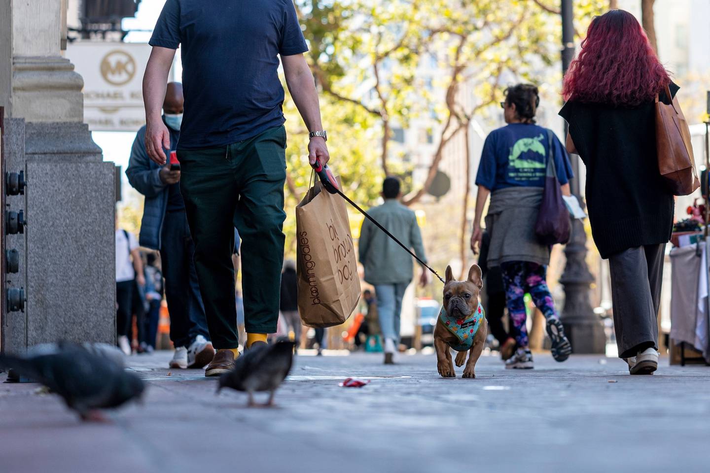 Un comprador lleva una bolsa mientras pasea a su perro en San Francisco, California, Estados Unidos, el jueves 29 de septiembre de 2022.