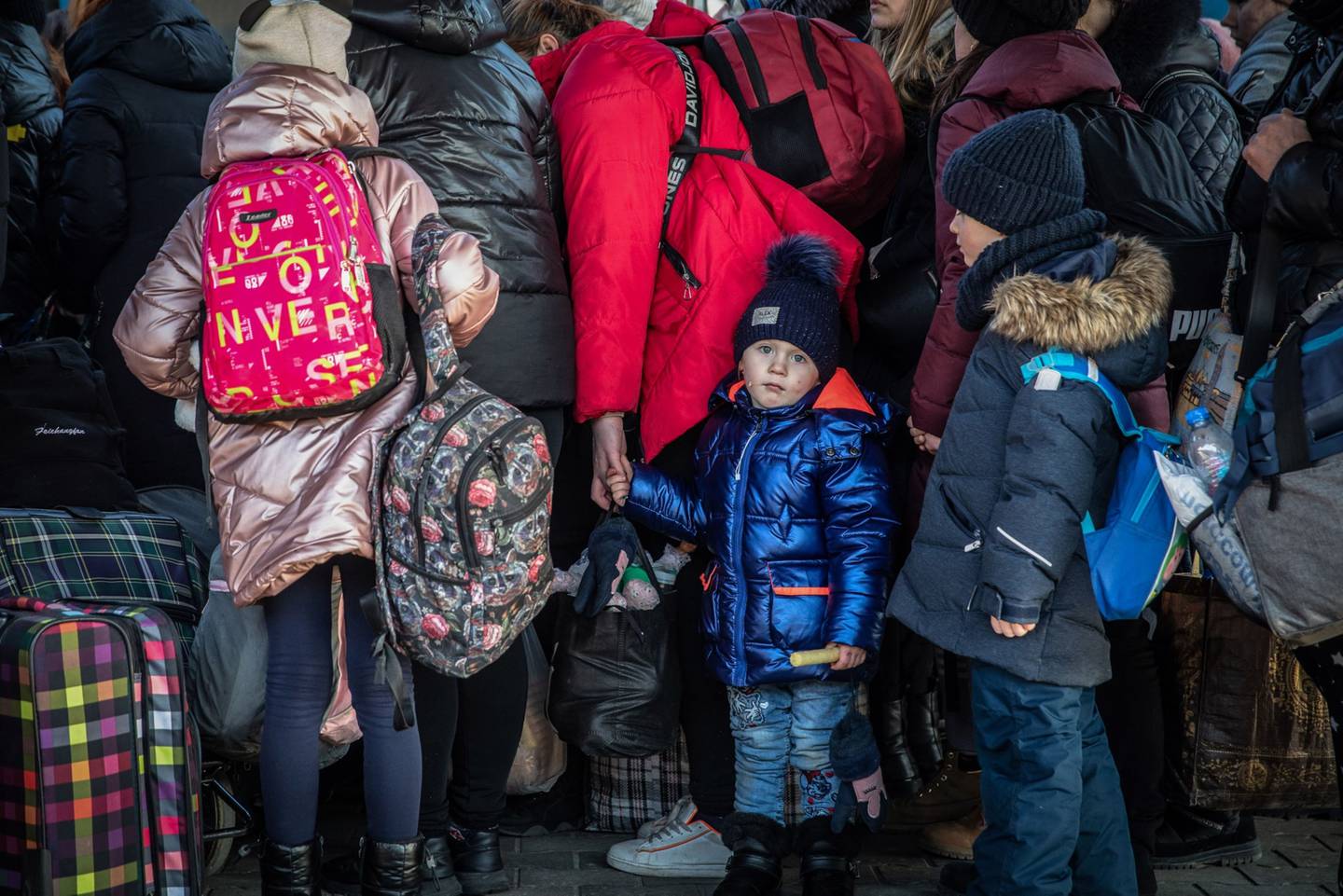 Ucranianos deslocados e seus filhos embarcam em um trem para seguir viagem na estação ferroviária de Przemysl, Polônia