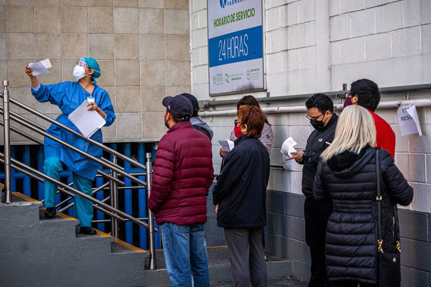 Trabajadores sanitarios entregan los resultados de pruebas Covid-19 afuera de una farmacia en Ciudad de México.dfd