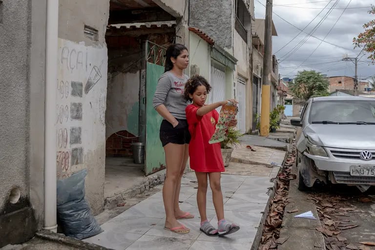 Jessica Couto, de 32 años, junto a su hija frente a su casa en Campo Grande, Río de Janeiro, el 10 de agosto de 2022.Photographer: Maria Magdalena Arrellaga/Bloombergdfd