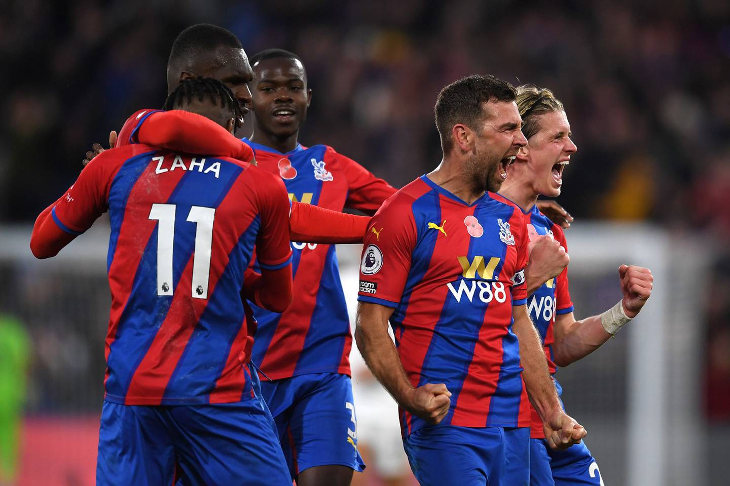 Conor Gallagher celebrates with teammates Wilfried Zaha and Christian Benteke of Crystal Palace after scoring their team's second goal during the Premier League match between Crystal Palace and Wolverhampton Wanderers at Selhurst Park on November 06, 2021 in London, England.