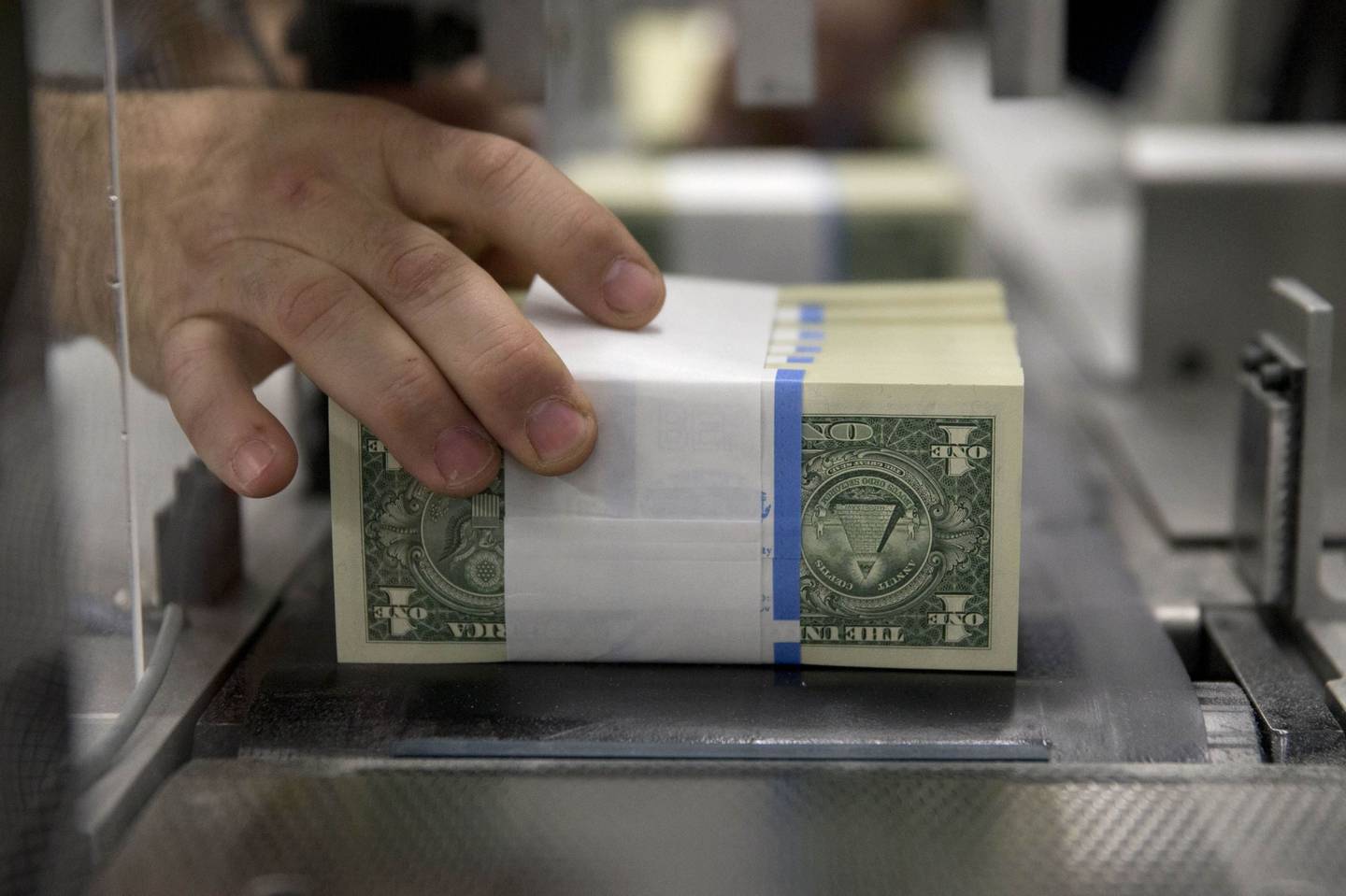 Billetes de un dólar son manipulados mientras viajan a través de una máquina en la Oficina de Grabado e Impresión de Estados Unidos en Washington, D.C., Estados Unidos, el martes 14 de abril de 2015.