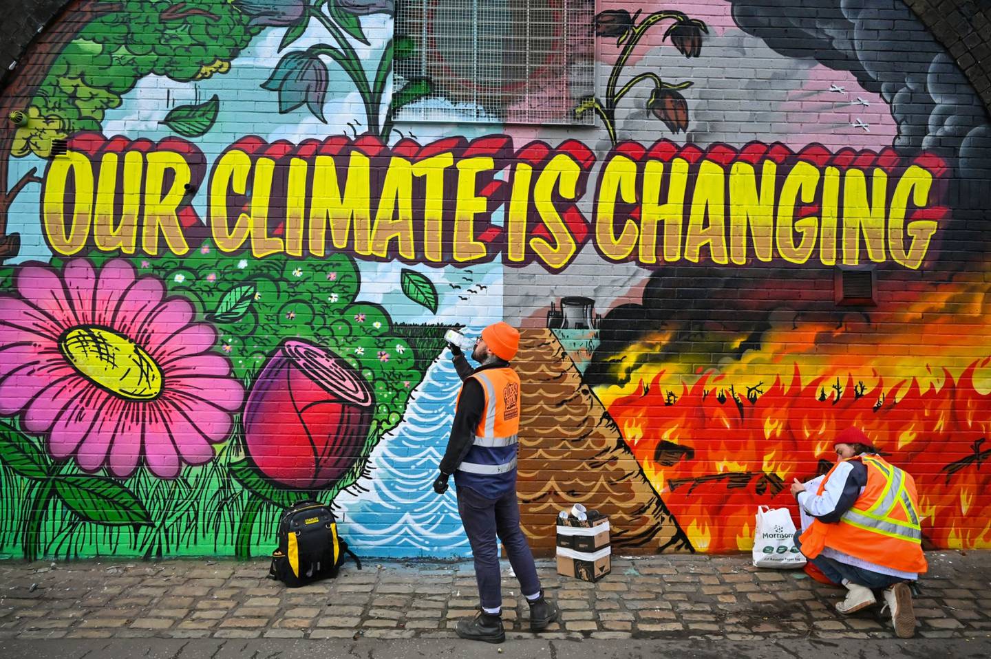 Artistas pintan un mural junto a la autopista Clydeside, cerca del Scottish Events Centre, que acogerá la Cumbre del Clima de la ONU COP26 a finales de este mes, el 13 de octubre de 2021 en Glasgow, Escocia.  Fotógrafo: Jeff J Mitchell/Getty Images
