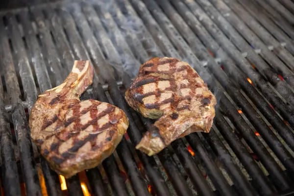 Beef steak on a barbecue griddle.