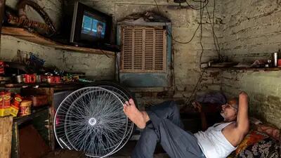 Un vendedor mira la televisión mientras descansa en el interior de un taller de reparación de bicicletas en Nueva Delhi, India, el viernes 19 de mayo de 2023. El calor extremo que asoló partes del sudeste asiático el mes pasado se debió en gran medida al cambio climático inducido por el hombre, según el análisis de un equipo de científicos. Fotógrafo: Anindito Mukherjee/Bloomberg