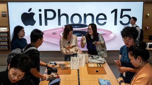 Una mujer gesticula mientras ella y otros compran el recién lanzado iPhone 15 y otros productos de Apple en una tienda insignia, el 22 de septiembre de 2023 en Beijing, China.