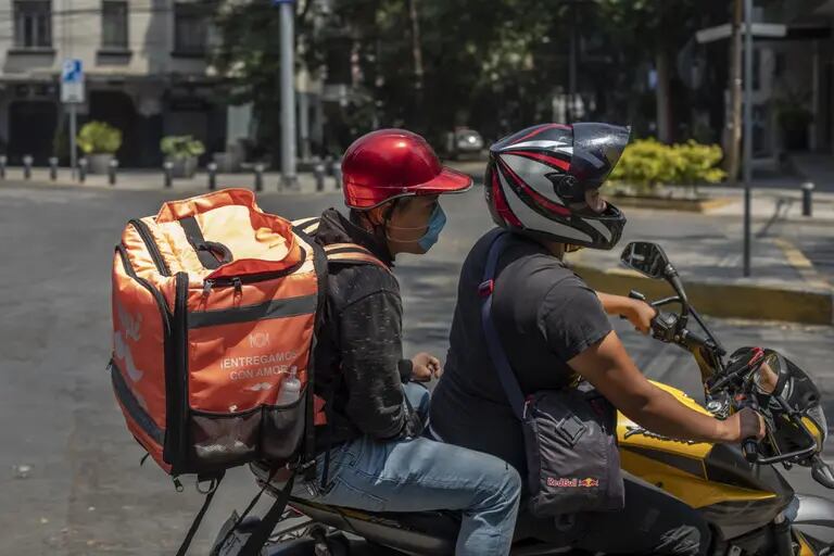Un trabajador con una máscara protectora conduce una motocicleta mientras realiza una entrega de la aplicación Rappi en Ciudad de México, el viernes 3 de abril de 2020.dfd