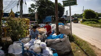 Voluntarios llenan un carro con residuos plásticos para su clasificación en un centro de reciclaje de Rayong, Tailandia, el miércoles 14 de diciembre de 2022.
