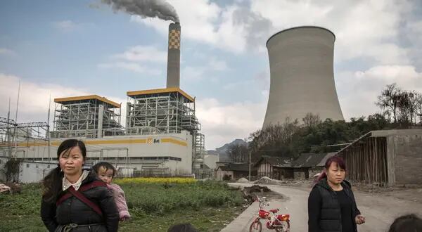 CONDADO DE LIUZHI, CHINA - 7 DE FEBRERO: Los aldeanos chinos permanecen cerca de una central eléctrica estatal de carbón recién construida el 7 de febrero de 2017 en el condado de Liuzhi, provincia de Guizhou, sur de China. Una historia de fuerte dependencia de la quema de carbón para obtener energía ha convertido a China en la fuente de casi un tercio de las emisiones totales de dióxido de carbono (CO2) del mundo.  (Foto de Kevin Frayer/Getty Images)