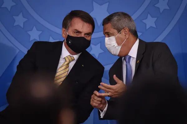 Jair Bolsonaro, presidente de Brasil, a la izquierda, y Walter Braga Netto, jefe de gabinete de Brasil, llevan una máscara protectora mientras hablan durante un evento en el Palacio de Planalto en Brasilia, Brasil, el viernes 15 de mayo de 2020.