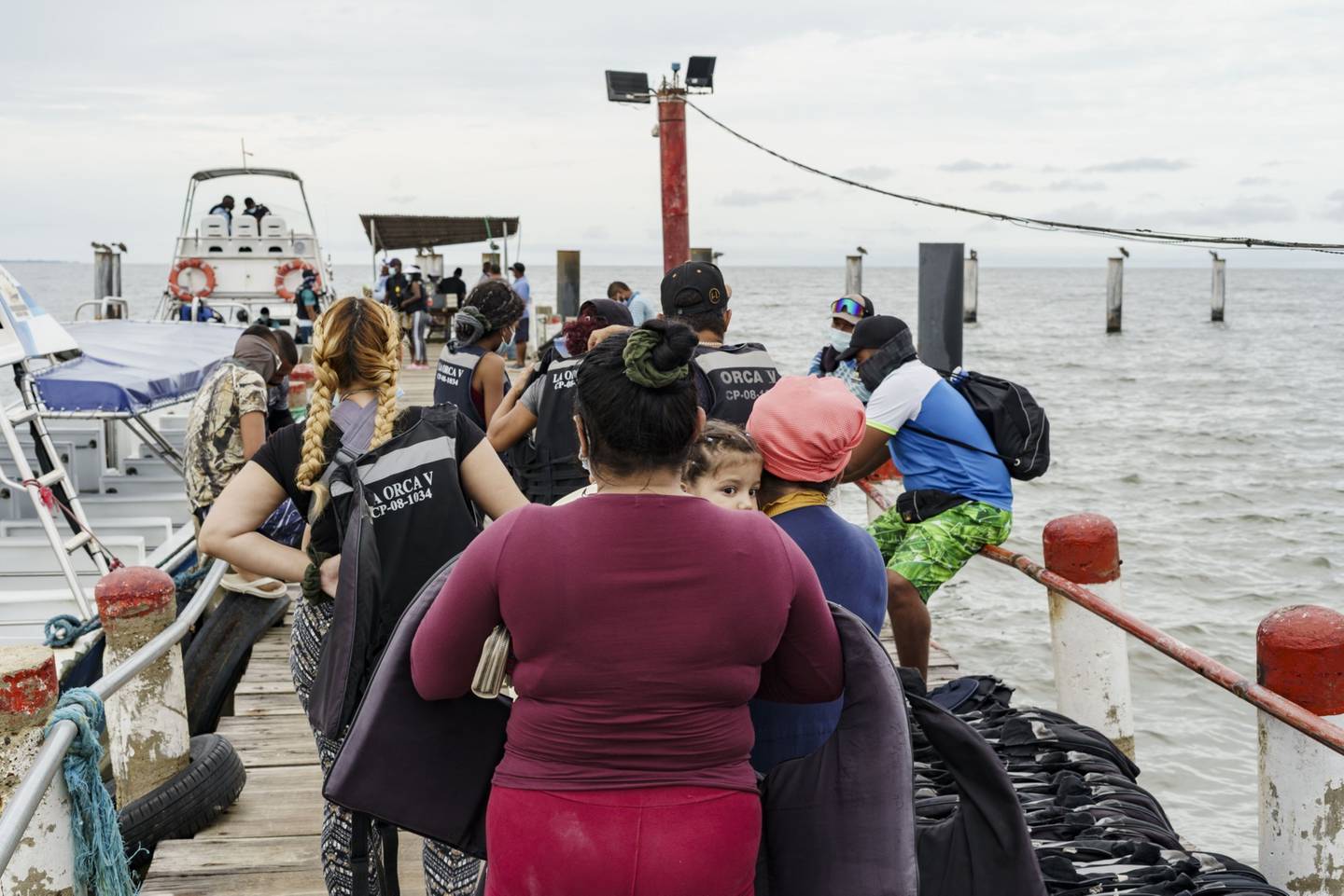 Migrantes esperan para abordar botes en la ciudad colombiana de Necoclí.dfd