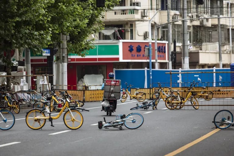 Um entregador de comida navega entre bicicletas compartilhadas formando uma barricada temporária durante um bloqueio.Fonte: Bloombergdfd