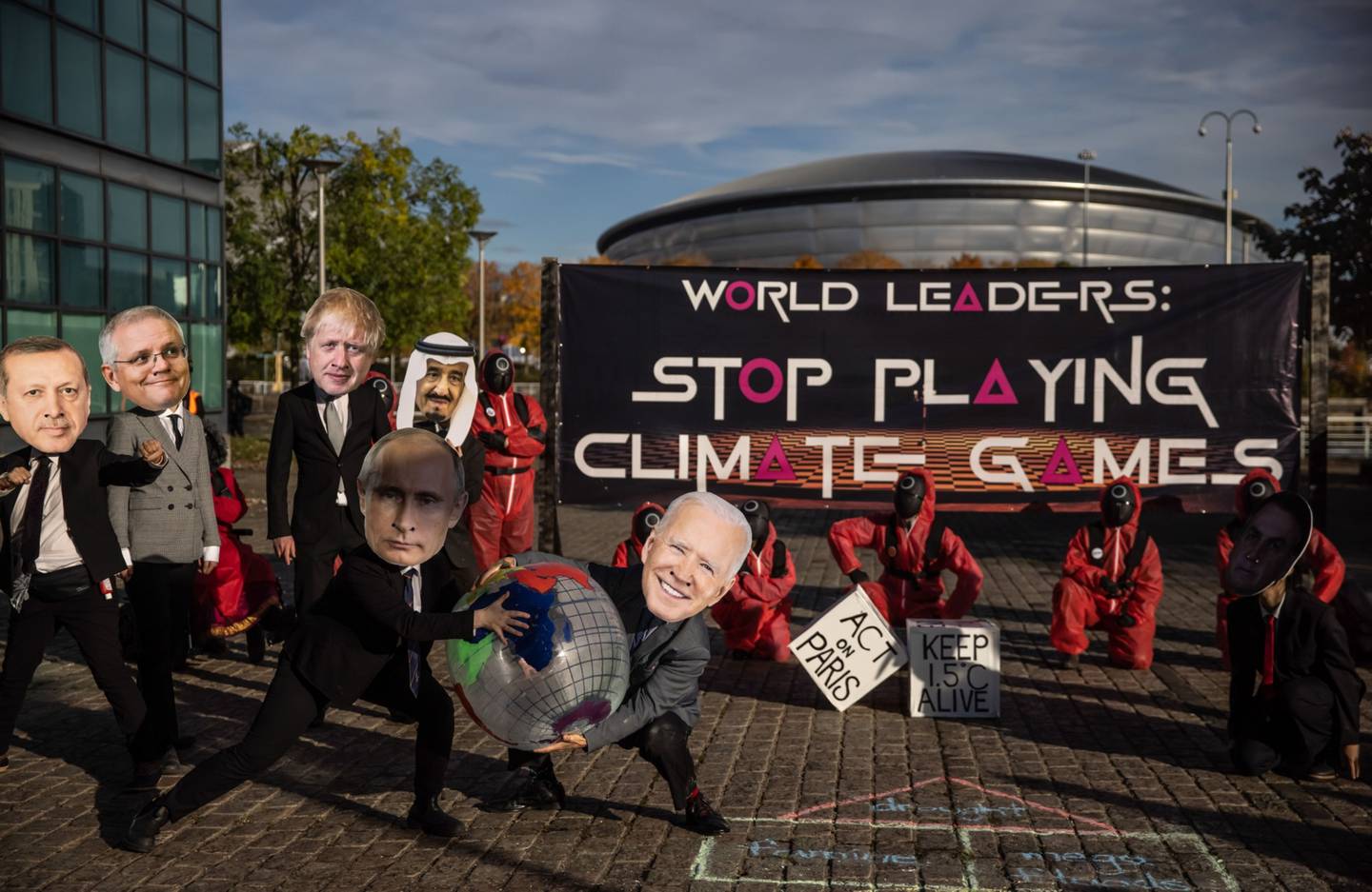 Activistas del cambio climático del Equipo de Acciones de Glasgow, con máscaras que representan a líderes mundiales, en una manifestación con el tema del "Juego del Calamar" durante la la COP26 en Glasgow, Reino Unido.