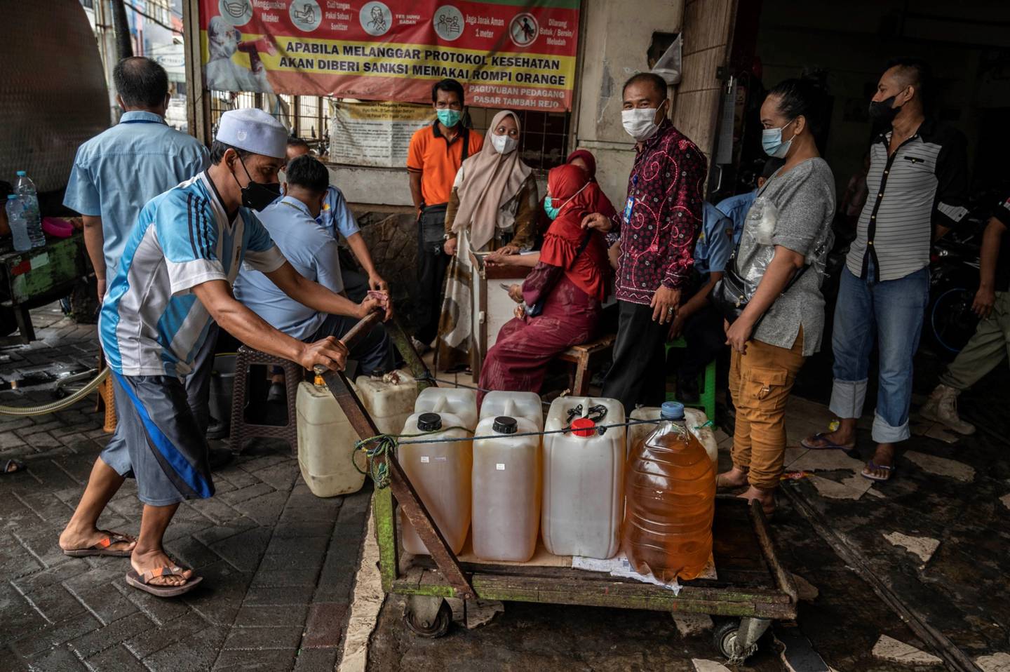 La gente hace cola para comprar aceite de cocina proporcionado por el gobierno local en Surabaya. Fotógrafo: Juni Kriswanto/AFP/Getty Images