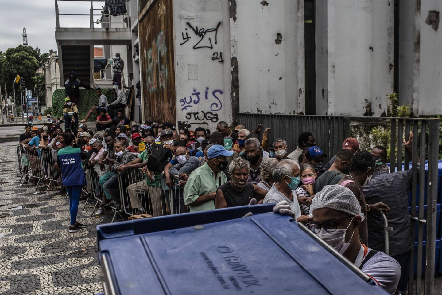 People stand in line to receive food outside the Biblioteca Parque Estadual in downtown Rio de Janeiro, Brazil.