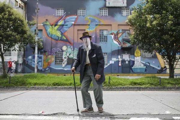 Un peatón lleva una mascarilla casera mientras camina en Bogotá, Colombia, el domingo 5 de abril de 2020.