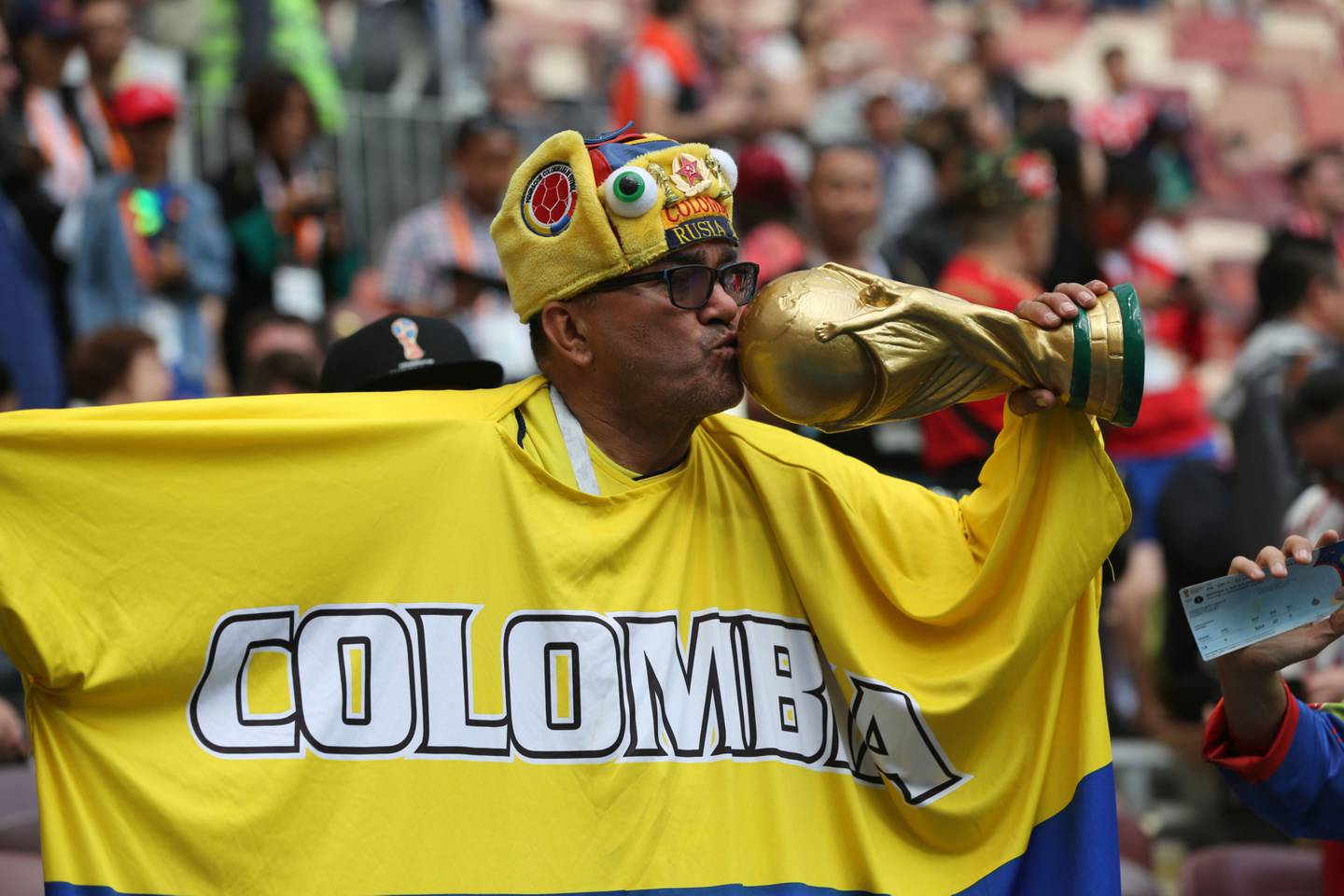 Un fanático del fútbol de Colombia besa una réplica del trofeo de la Copa Mundial durante la ceremonia de apertura de la Copa Mundial de la FIFA en el estadio Luzhniki en Moscú, Rusia, el jueves 14 de junio de 2018