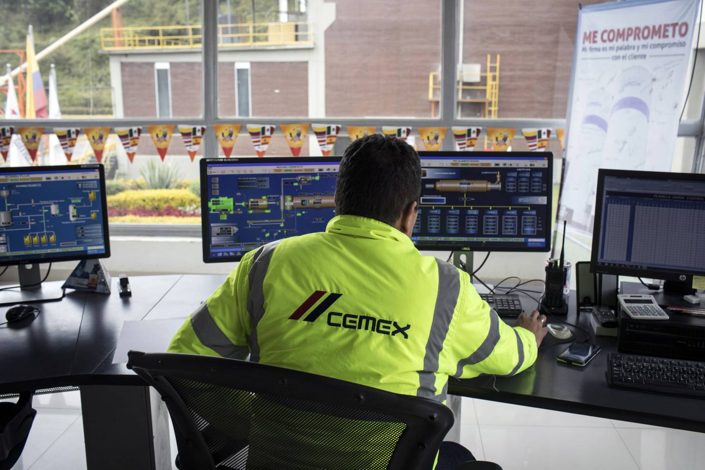 A worker uses computers to monitor the control panels at the Cemex Latam Holdings SA production facility in La Calera, Cundinamarca department, Colombia. Cemex shares rose on the Mexican Stock Exchange on Friday, June 24. Photographer: Nicolo Filippo Rosso/Bloomberg