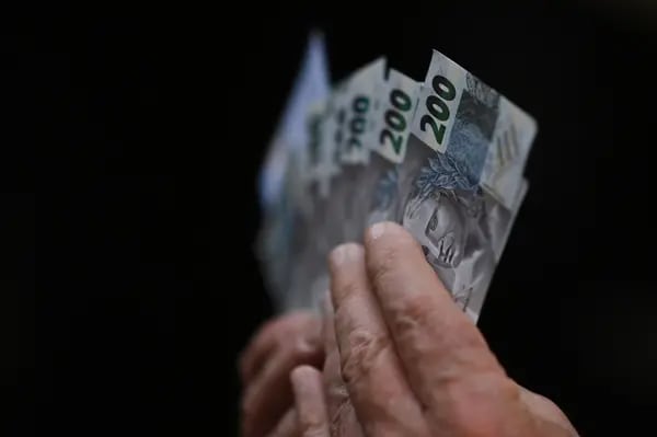 Una persona sostiene nuevos billetes de 200 reales fuera del Banco Central de Brasil en Brasilia, Brasil, el miércoles 2 de septiembre de 2020.