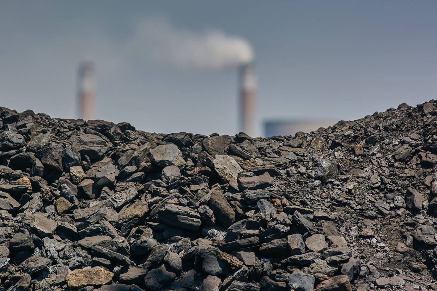 A coal pile in front of the towers of the Eskom Holdings SOC Ltd. Kendal coal-fired power station in Mpumalanga, South Africa, on Friday, Oct. 15, 2021.