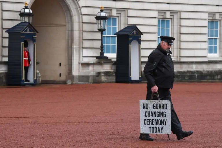 Un empleado lleva un cartel en el que se lee "No hay ceremonia de cambio de guardia hoy" en el Palacio de Buckingham en Londres, Reino Unido, el jueves 8 de septiembre de 2022. dfd
