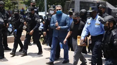 Oficiales de policía hondureños escoltan a Juan Orlando Hernández, expresidente de Honduras, centro, al Aeropuerto Internacional Toncontín (TGU) en Tegucigalpa, Honduras, el jueves 21 de abril de 2022.
