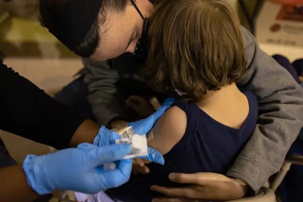 Un trabajador sanitario coloca una tirita después de administrar una dosis de la vacuna Covid-19 de Pfizer-BioNTech a un niño en una clínica de vacunación del Ejército de Salvación en Filadelfia, Pensilvania, Estados Unidos, el viernes 12 de noviembre de 2021.