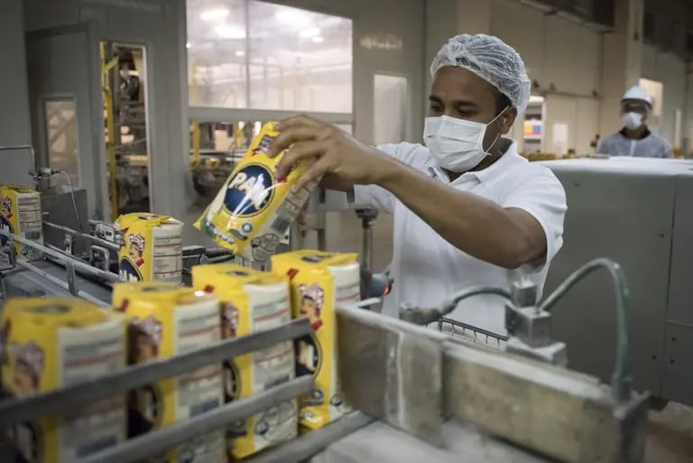 Un empleado coloca sacos de harina de maíz de la marca Empresas Polar SA P.A.N. en una cinta transportadora en las instalaciones de procesamiento y distribución de la empresa en Turmero, Venezuela, el jueves 16 de marzo de 2017. dfd