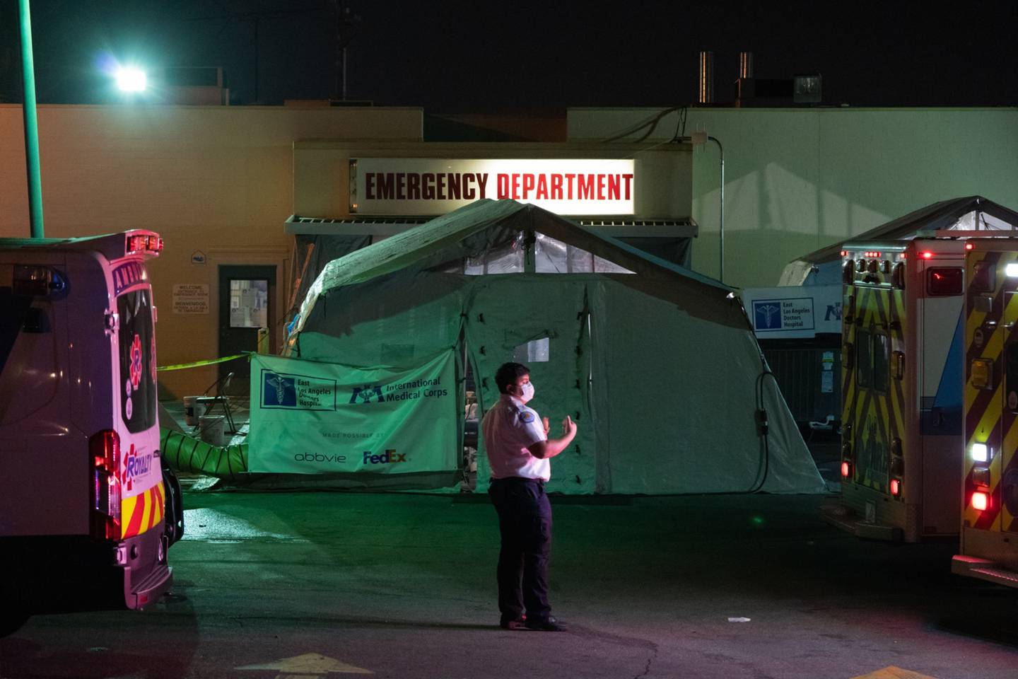 Un técnico de emergencias médicas dirige una ambulancia fuera de la sala de emergencias del East Los Angeles Doctors Hospital, en Los Ángeles.