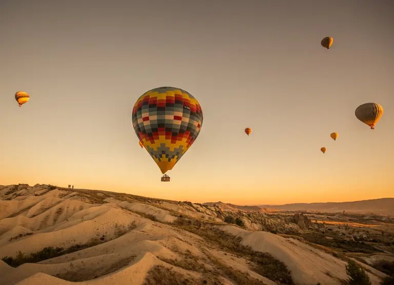 The hot air balloons over the hills and the fields during sunset in Cappadocia, Turkeydfd