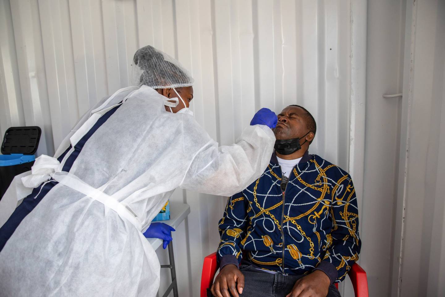 Un trabajador de la salud administra una prueba de hisopo nasal en un sitio de pruebas móviles fuera del centro comercial Richmond Corner en el distrito de Milnerton, Sudáfrica, el jueves 2 de diciembre de 2021. Fotógrafo: Dwayne Senior/Bloomberg