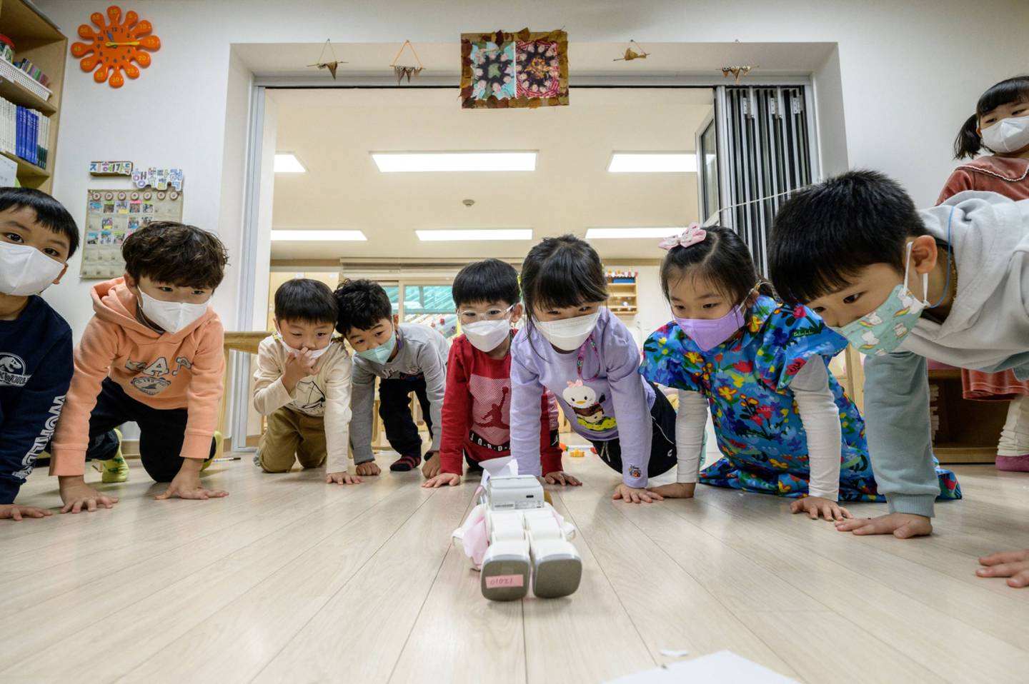 Estudiantes hacen flexiones con un robot en Seúl.