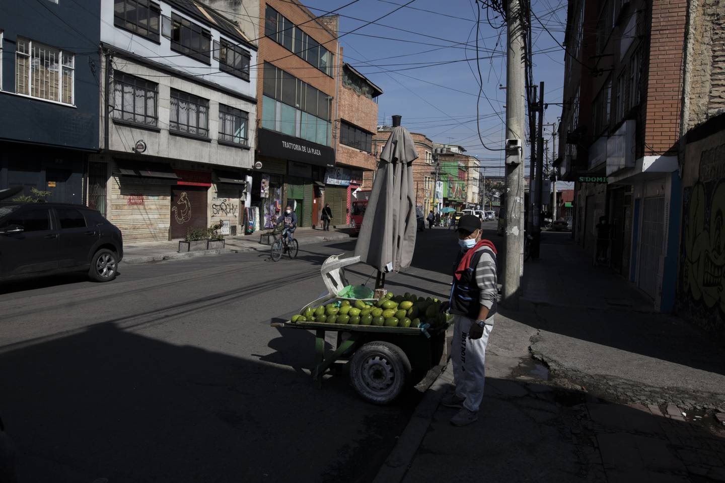Un vendedor ambulante junto a tiendas cerradas temporalmente debido a una medida para contener la pandemia de covid-19 en Bogotá, Colombia, el sábado 25 de abril de 2021.