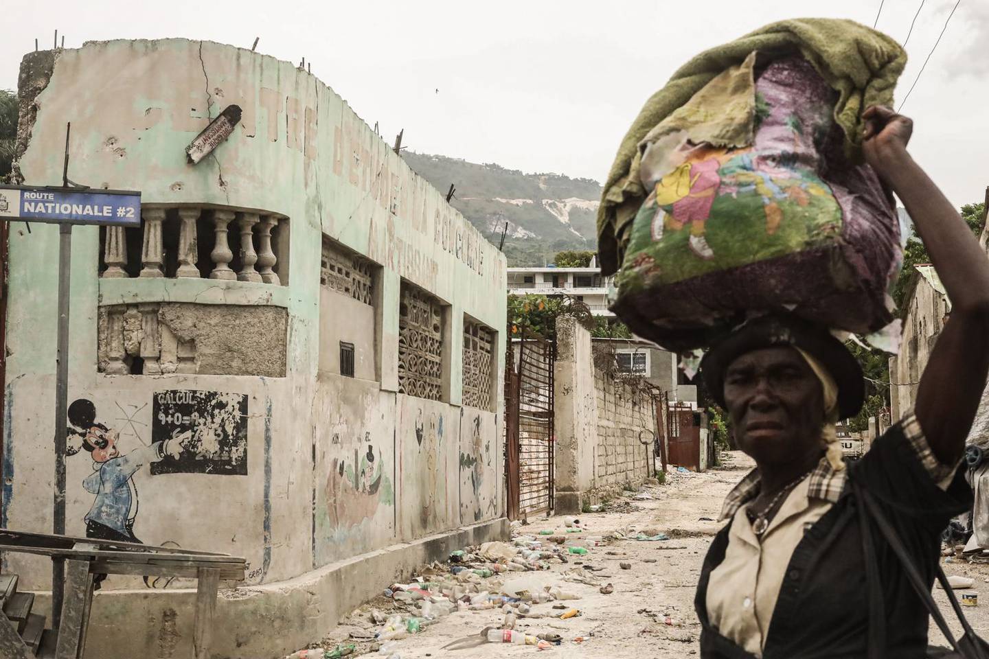 Un peatón cruza una calle llena de basura en el barrio de Martissant de Puerto Príncipe, Haití, el martes 17 de agosto de 2021. Haití, la nación más pobre del hemisferio occidental, ha estado luchando con la escasez de alimentos, la violencia generalizada y el caos político tras el asesinato del presidente Jovenel Moise el mes pasado. Fotógrafo: Jonathan Alpeyrie/Bloomberg