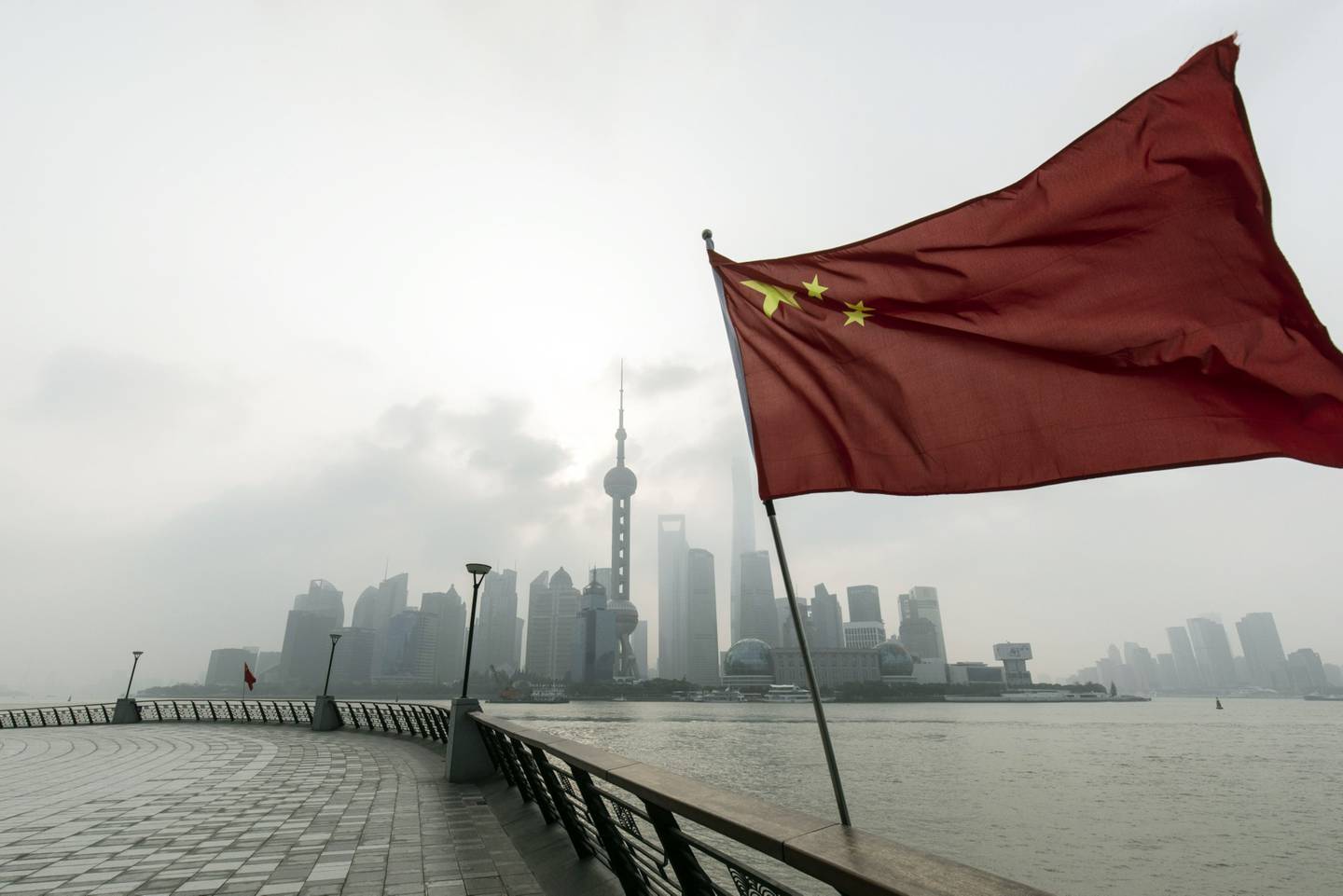 Una bandera china frente a los edificios del distrito financiero Lujiazui de Pudong en Shanghái, China, el lunes 17 de octubre de 2022.