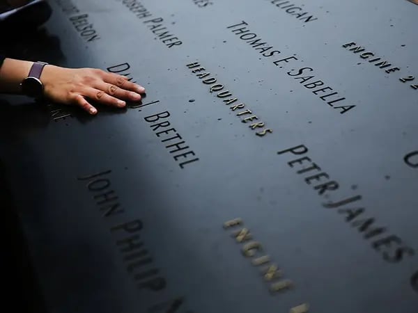 Una mujer toca los nombres inscritos en el memorial de Ground Zero.