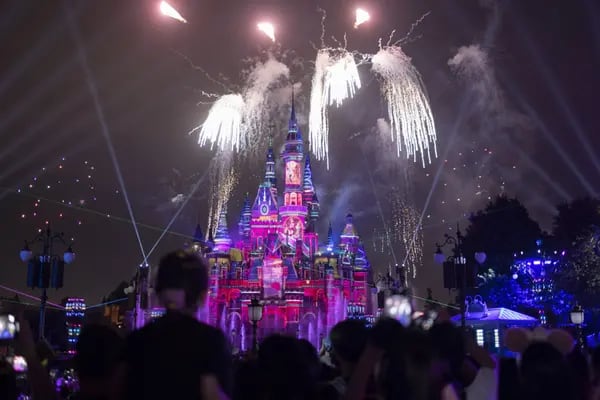 La gente asiste al espectáculo nocturno del Castillo Encantado de Cuentos en Shanghai Disneyland.