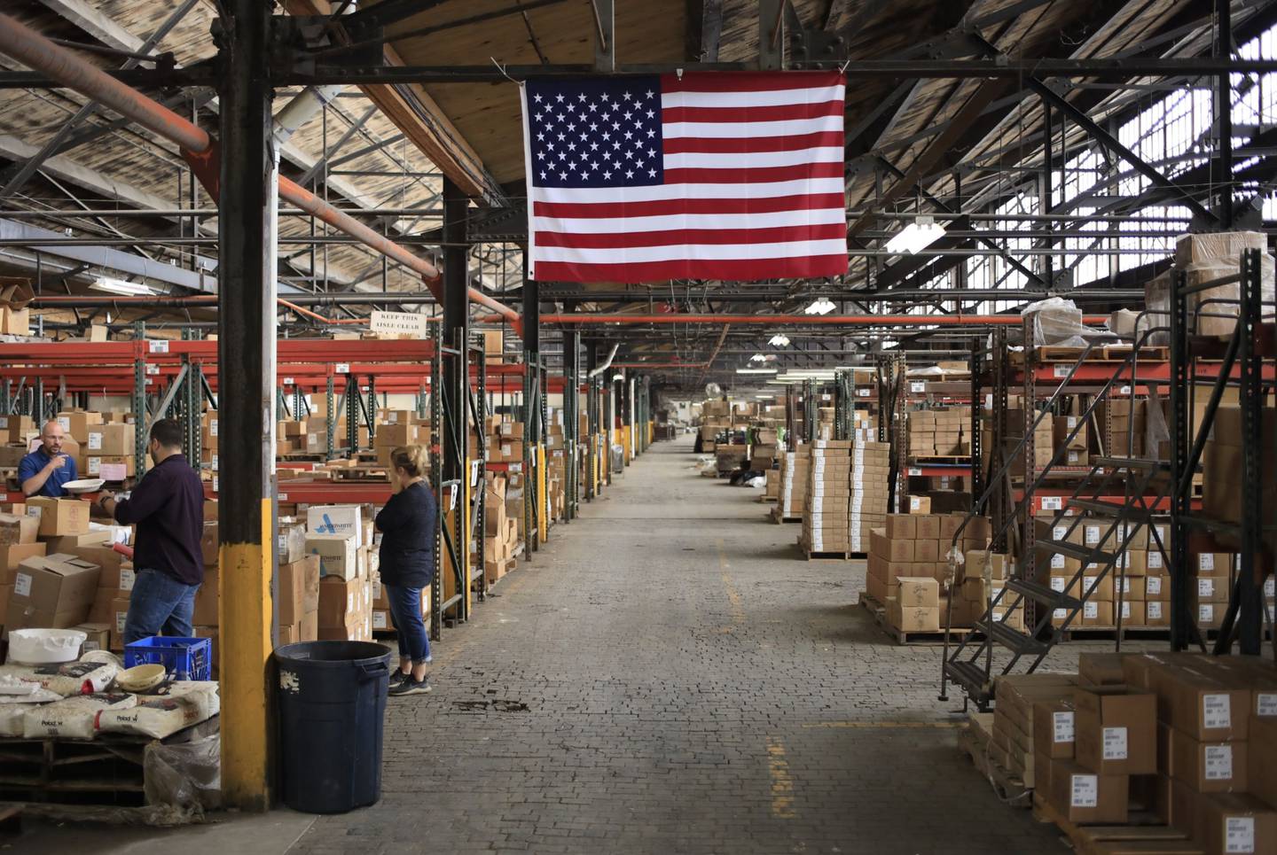 Una bandera estadounidense en un almacén de la fábrica Fiesta Tableware Co. en Newell, Virginia Occidental, Estados Unidos, el jueves 22 de julio de 2021.  Fotógrafo: Luke Sharrett/Bloomberg