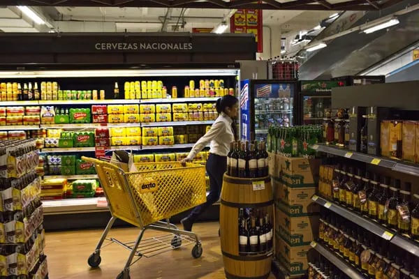 Un empleado empuja un carrito de compras más allá del pasillo de cerveza en una tienda Almacenes Éxito SA en Bogotá, Colombia, el jueves 20 de abril de 2017.