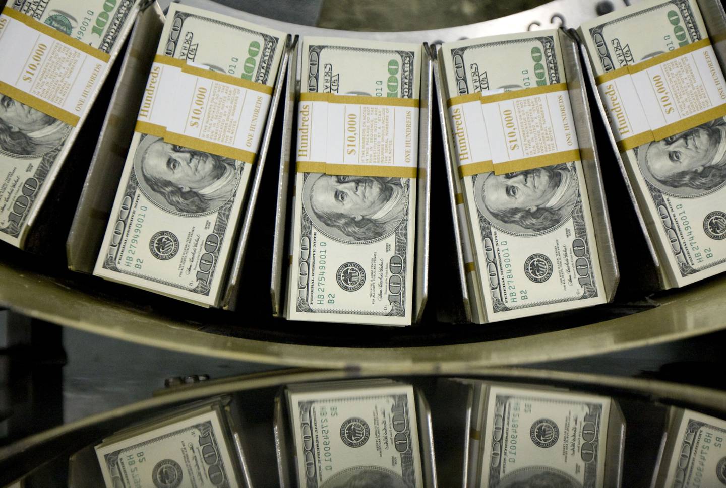 Stacks of one hundred dollar bills pass through a circulator machine at the Bureau of Engraving and Printing in Washington, D.C., U.S., on Wednesday, Oct. 14, 2009.
