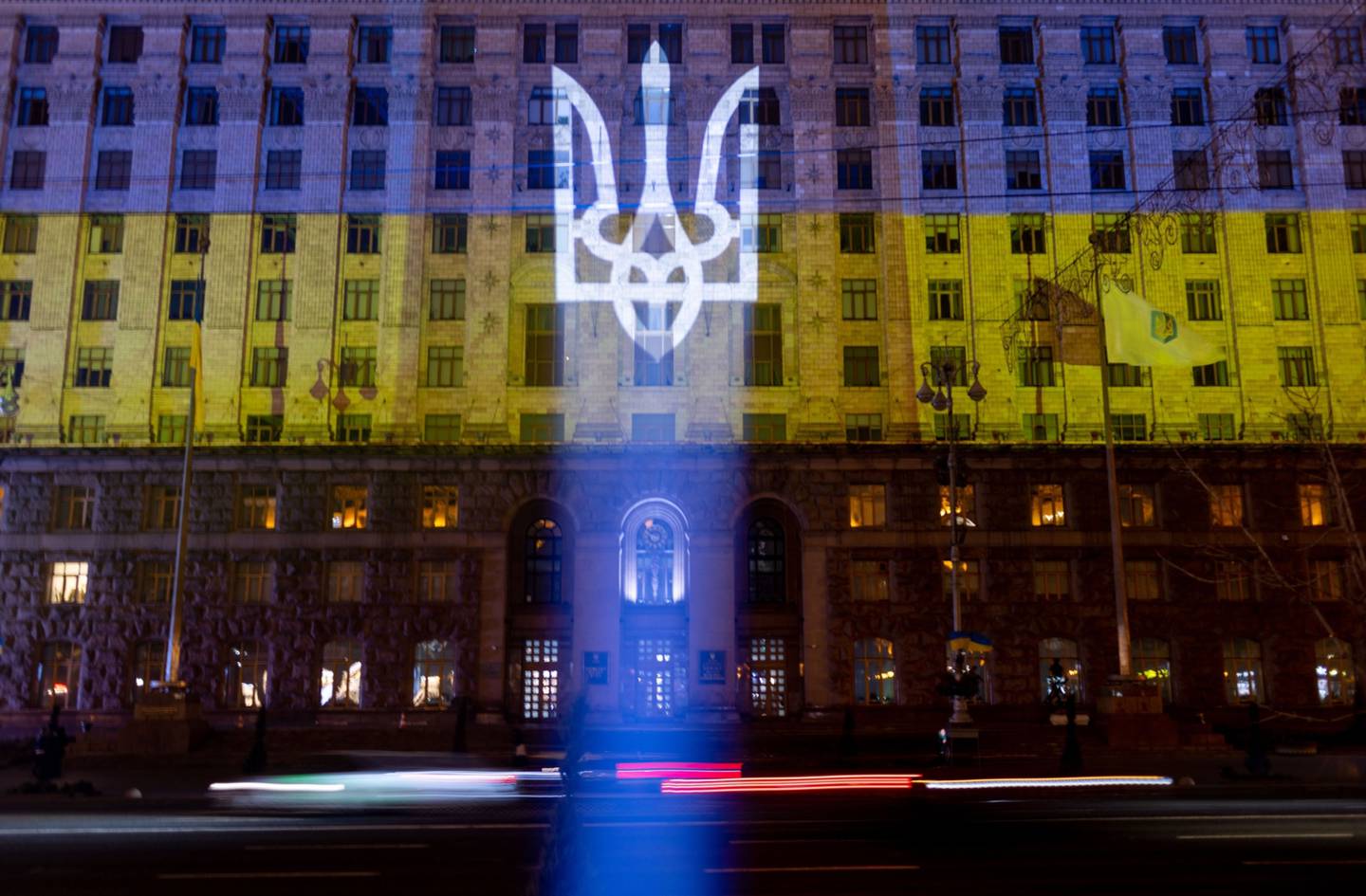 El escudo de armas y la bandera nacional de Ucrania se proyectan en un edificio durante un "Día de la Unidad" en Kiev, Ucrania, el miércoles 16 de febrero de 2022.