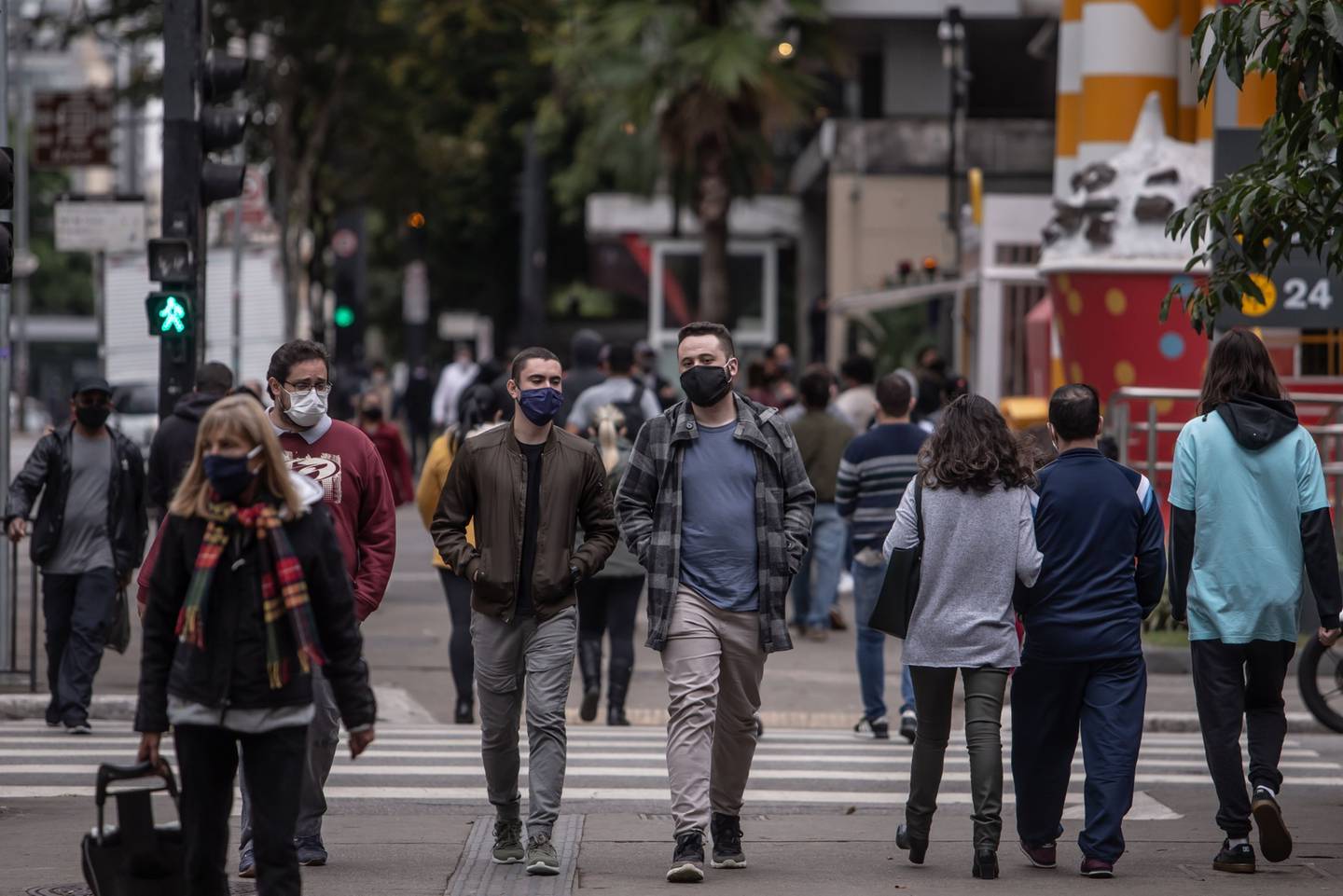 Pedestrians wearing protective mask cross Paulista Avenue in Sao Paulo, Brazil.