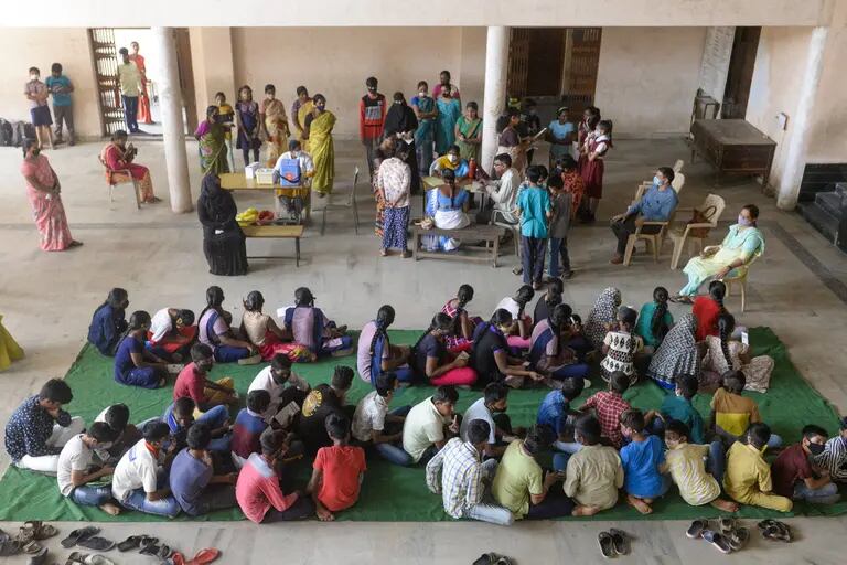 Estudantes com seus pais esperam para se registrar para vacinação em uma escola em Hyderabad em 22 de março.Fotógrafo: Noah Seelam/AFP/Getty Imagesdfd