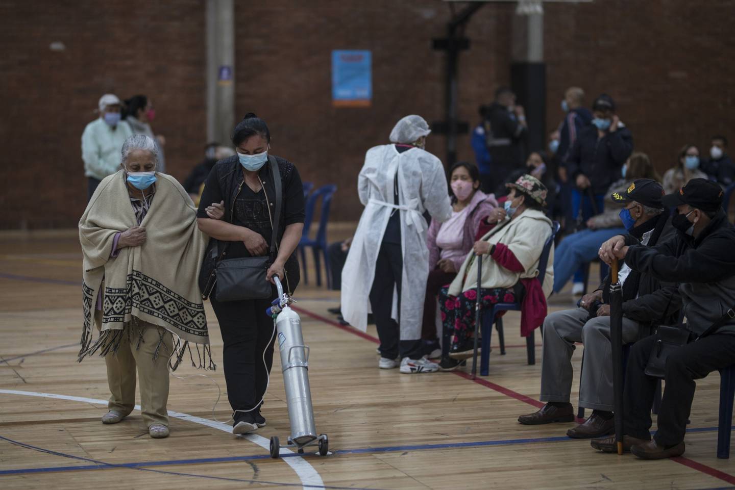 A patient using an oxygen tank leaves an  observation area after receiving a Covid-19 vaccine at the Cayetano Canizares Coliseum in Bogota, Colombia, on Friday, March 12, 2021. Colombia is lagging behind its South American neighbors with only 0.3% of the population vaccinated, even as the country sees the second-highest number of infections on the continent. Photographer: Ivan Valencia/Bloomberg