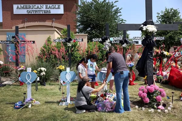 Una familia reza en el monumento conmemorativo instalado cerca del lugar donde se produjo un tiroteo masivo en el centro comercial Allen Premium Outlets de Allen, Texas, el 9 de mayo de 2023.