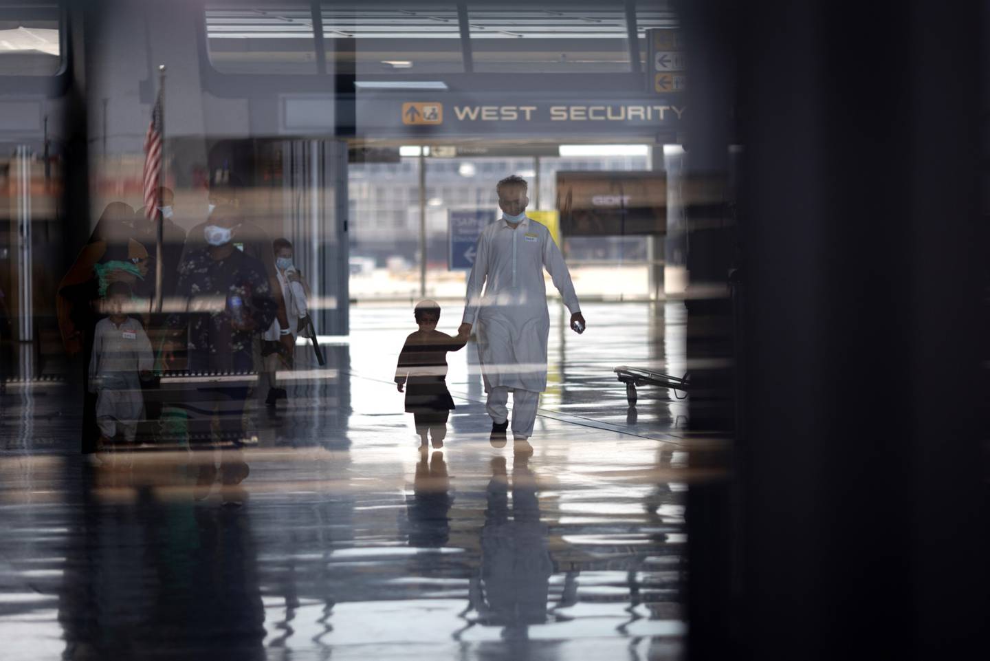 Refugiados evacuados de Kabul, Afganistán, caminan desde el aeropuerto internacional de Dulles hacia un autobús que los llevará a un centro de procesamiento de refugiados el 26 de agosto de 2021 en Dulles, Virginia. Foto de Win McNamee/Getty Images