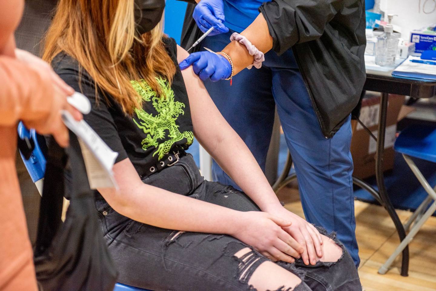Un trabajador de la salud administra una vacuna contra el covid-19 a un adolescente en un sitio de vacunación en Long Beach, Nueva York.