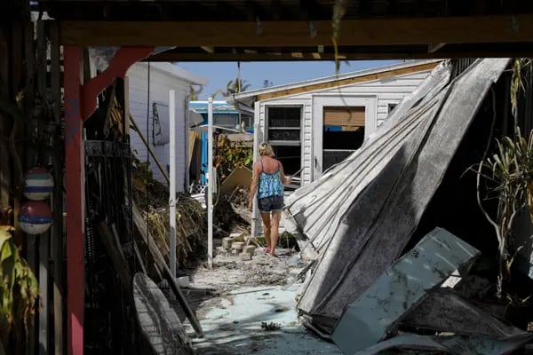 A resident walks inside her damaged house following Hurricane Ian in Matlacha, Florida, US, on Wednesday, Oct. 5, 2022. President Biden and Governor DeSantis have feuded over political issues, including migrants, but are coordinating on assistance for Floridians hit by a hurricane Biden's called "among the worst in the nation's history."